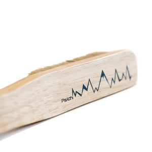 The head of a wooden boar hair climbing brush with black psychi climbing shop logo and lightning design.