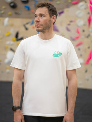 Bouldering clothing unisex tee with graphic design shown on a male model at indoor climbing wall.