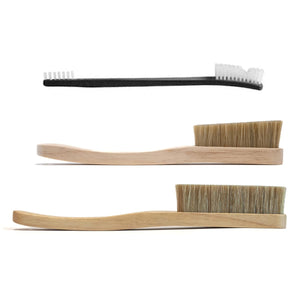 a smaller black plastic climbing brush with two larger wooden boar hair brushes in a gift set