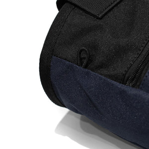 An elastic climbing brush holder on a navy blue climbing chalk bag