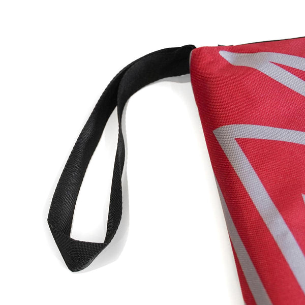A black carry strap attached to a red and grey rock climbing guidebook case