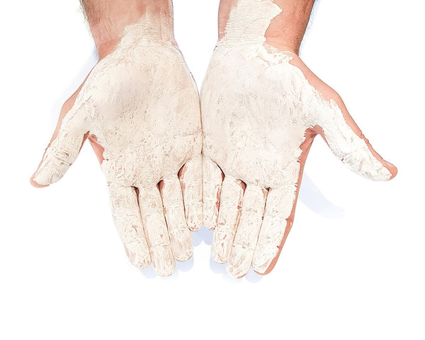 A climbers hands covered in dry liquid clmbing chalk