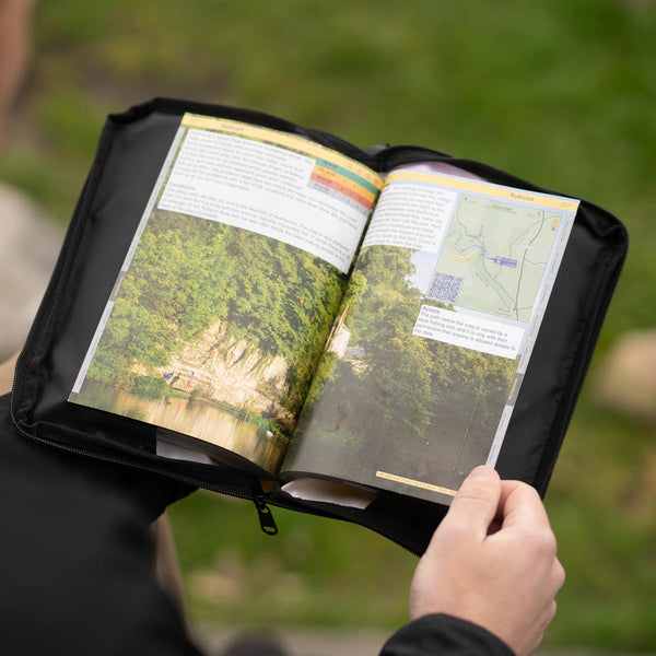 A climber eyes a route in a local Peak District guidebook in a psychi guide book protector case