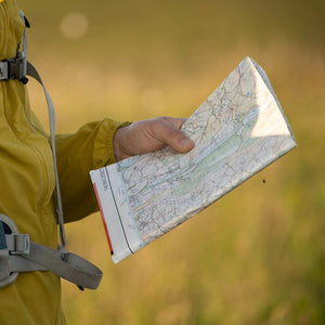 A mountain guide holding an OS map while teaching a group to navigate