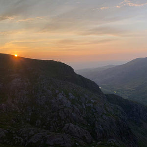 The sun sets over a rocky outcrop in Snowdonia national park.