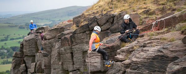 A woman being taught to abseil at Castle Naze in the peak district.
