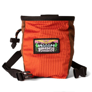 An orange and brown corduroy climbing chalk bag with a black waist strap.
