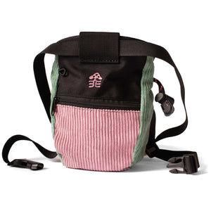 The rear or a pink and light green corduroy chalk bag with a pink embroidered logo, zip pocket and a black waist strap.