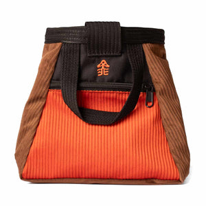 A burnt orange, brown and black corduroy bouldering bucket with black carry handle and an accessory pocket with zip closure.