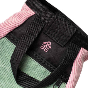 A pink embroidered mushroom logo sewn into the back of a psychi bouldering chalk bucket.