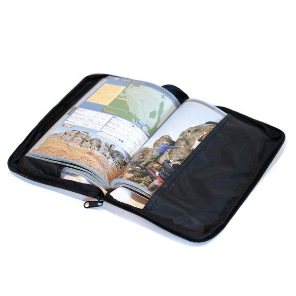 An open guidebook sits in a weatherproof protector case