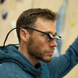 A climber wearing belay glasses belaying his climbing partner at Depot climbing in Manchester