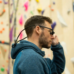 A climber wearing belay glasses prepares to belay his climbing partner at Depot climbing in Manchester