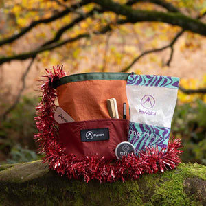 A bouldering chalk bag gift bundle with climbing tape, chalk and climbing brushes sits on a mossy rock at Cratcliffe, Yorkshire