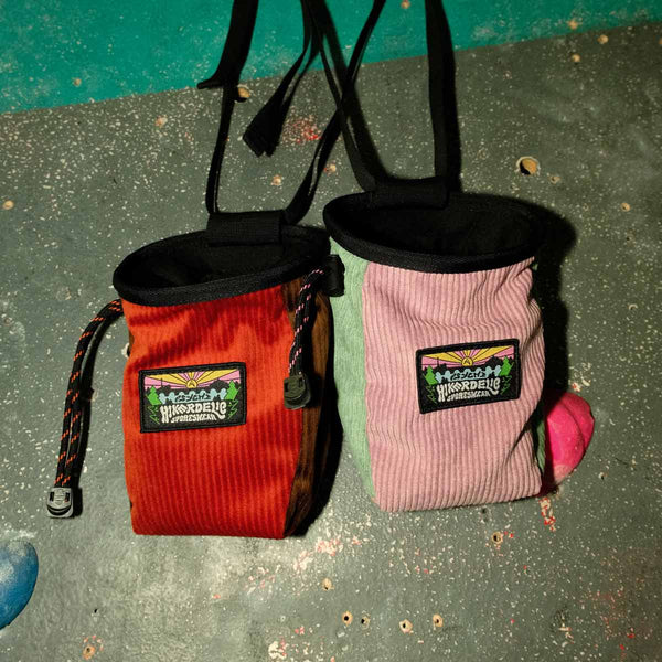 two rock climbing chalk bags hang from bouldering hand holds at Parthian Climbing Centre Manchester.