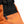 A light orange and black bouldering chalk bucket with drawstring closure and zip closure climbing accessory pockets