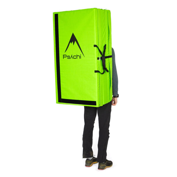 A man carrying a green triple fold bouldering mat on his back Psychi