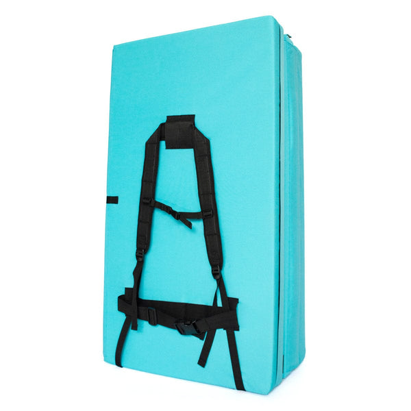 A folded up blue bouldering pad with shoulder carry straps measuring 60cm x 110cm x 37.5cm
