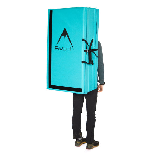 A man carrying an electric blue triple fold bouldering mat on his back Psychi