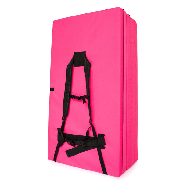 A folded up pink bouldering pad with shoulder carry straps measuring 60cm x 110cm x 37.5cm