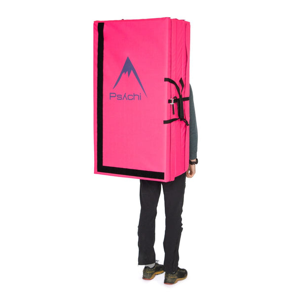 A man carrying a bright pink triple fold bouldering mat on his back Psychi