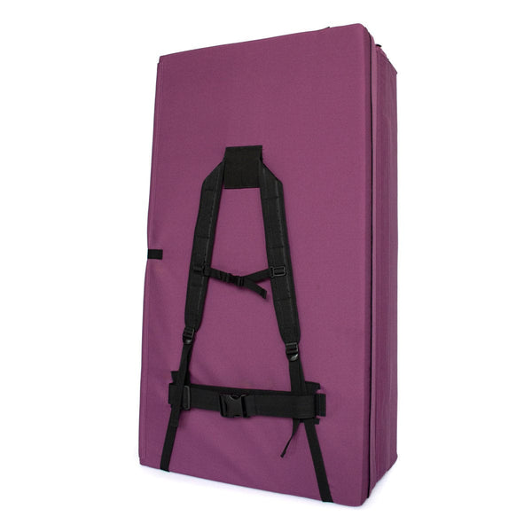 A folded up purple bouldering crash pad with shoulder carry straps measuring 60cm x 110cm x 37.5cm