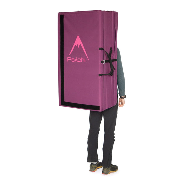 A man carrying a purple triple fold bouldering mat on his back Psychi