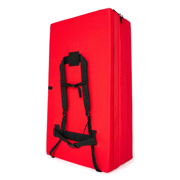 A folded up red bouldering crash pad with shoulder carry straps measuring 60cm x 110cm x 37.5cm