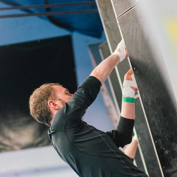 A crack climber hand jamming at Rockover Climbing Centre, Manchester with zinc oxide cotton tape wrapped around his wrists.