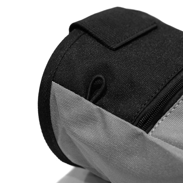 An elastic climbing brush holder on a light grey climbing chalk bag 