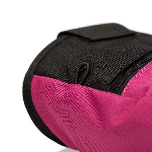 An elastic climbing brush holder on a magenta climbing chalk bag 