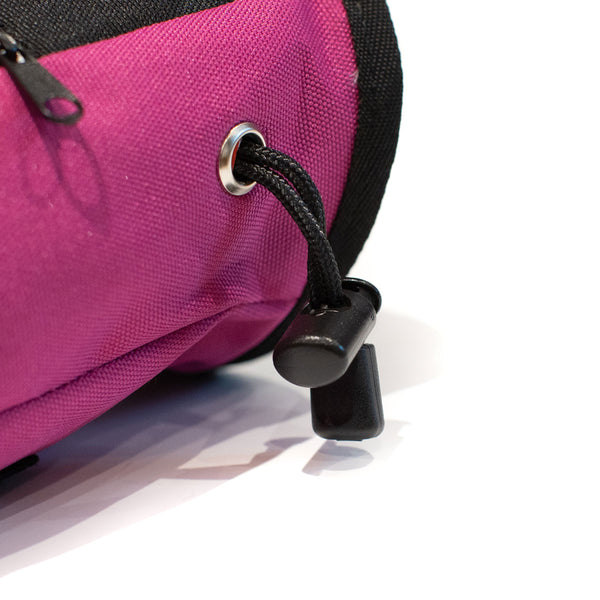 A Drawstring closure toggle on a magenta climbing chalk bag 