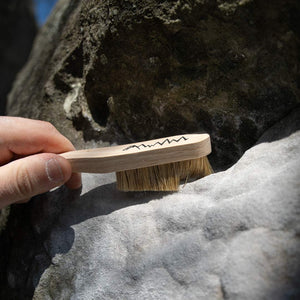 A climber brushes climbing chalk off a rock in fontainbleau, France. 