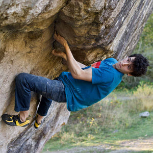 Rock climbing athlete Hamish McArthur climbing a boulder at Rubicon, Peak District