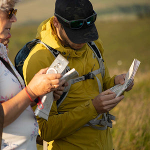 A mountain guide and a woman looking at maps during a nmountain navigation experience training adventure