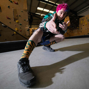 Bouldering athlete Max Milne posing with pink and blue hair at Last Sundance Climbing Centre in Leeds.