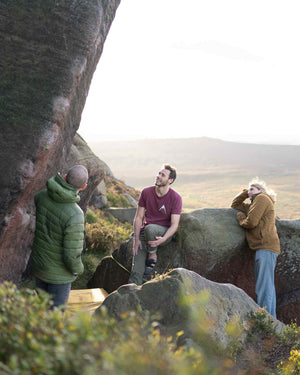 Three climbers at stange plantation in the peak district contemplate a boulder route