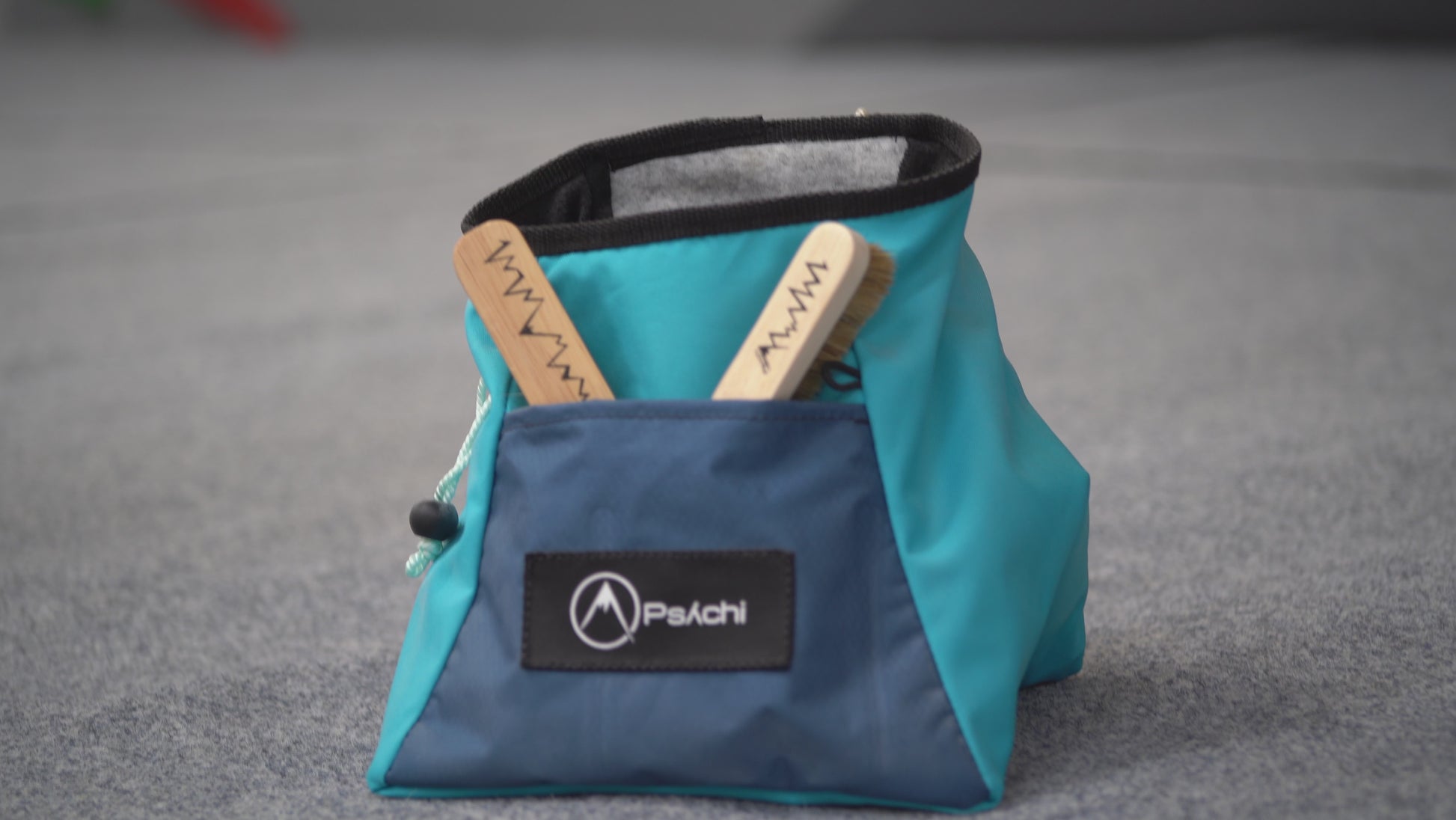 A climber using 3 different boar hair brushes to clean chalk from climbing holds at a climbing centre in Manchester