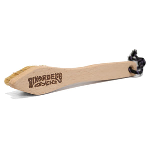 A wooden rock climbing brush with hikerdelic and psychi logo on the back