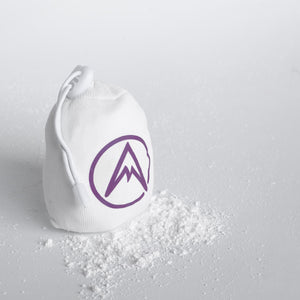 White refillable chalk ball with purple logo on a grey background