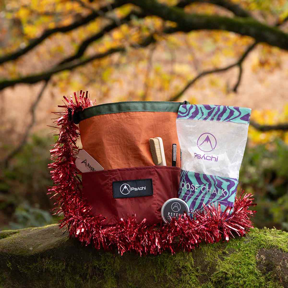 A rock climbing gift bundle for bouldering sits on top of a mossy rock at Cratcliffe, Yorkshire
