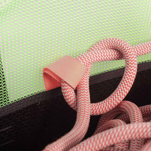 Close-up of red rope tied to a anchor loop inside a green mesh belaying bag