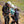 A climbing intstructor explaining and attaching a piece of safety equipment to two beingner climbers at Frogatt Edge in the Peak District.