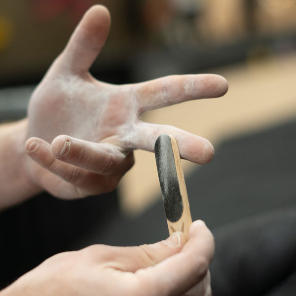 A climber at Depot climbing in Manchester uses a psychi skin file to remove tough dead skin from their climbing chalk covered hands
