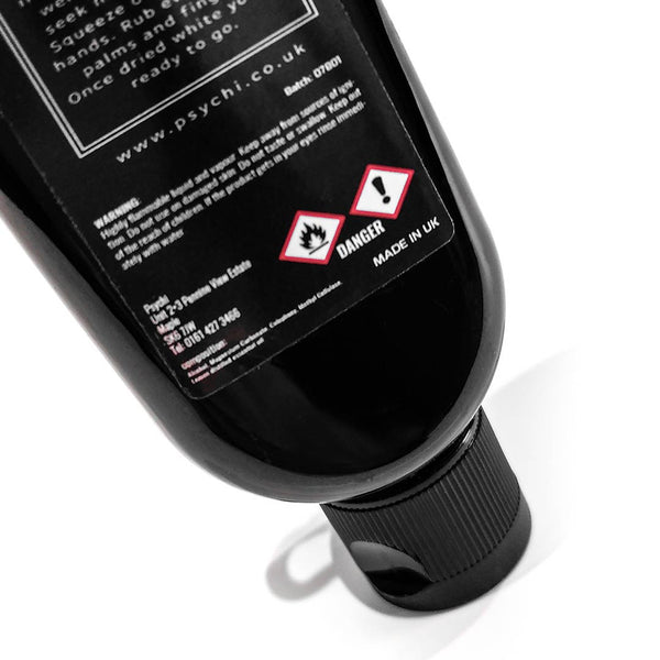 A black bottle of liquid chalk showing warning labels for a flammable liquid. 