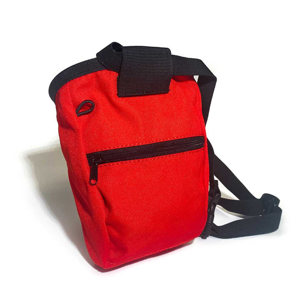 Rear of red chalk bag with zipped pocket, a black waist strap and a black drawstring closure.