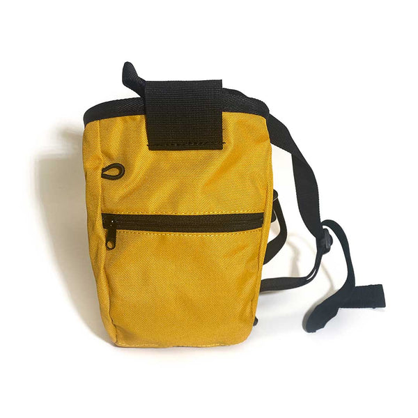 Rear of yellow chalk bag with zipped pocket, a black waist strap and a black drawstring closure.